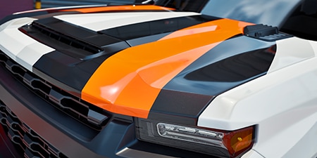 Close-up of the wrapped hood of a truck with deep recesses and compound curves.
