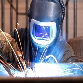 Workman in welding helmet.